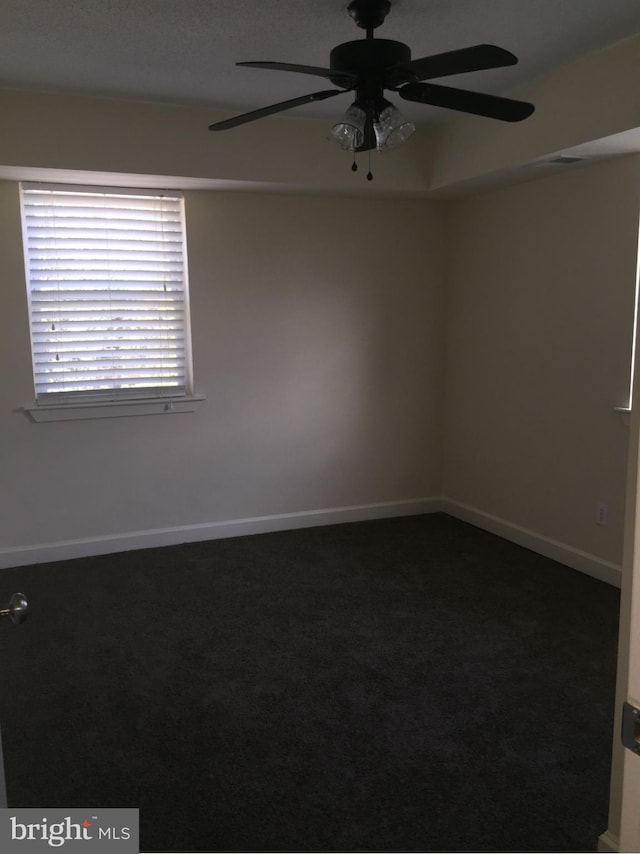 carpeted empty room with a ceiling fan and baseboards