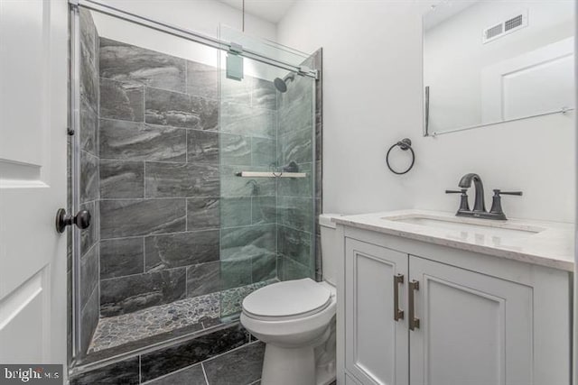 bathroom featuring toilet, a shower stall, visible vents, and vanity