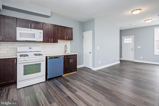 kitchen with dark wood-style floors, light countertops, white appliances, and backsplash