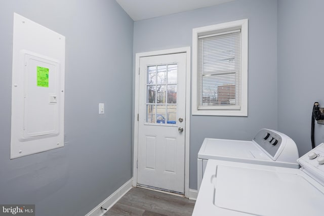 clothes washing area featuring washing machine and dryer, laundry area, dark wood-style flooring, baseboards, and electric panel