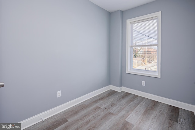 spare room with wood finished floors and baseboards