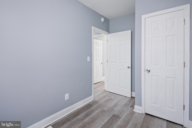 unfurnished bedroom with baseboards and wood finished floors