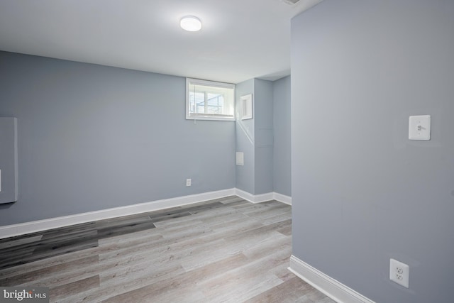 basement with baseboards and wood finished floors