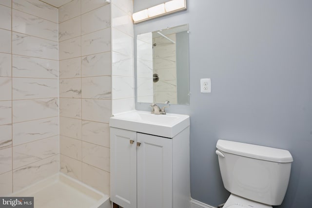 full bath with toilet, a tile shower, and vanity