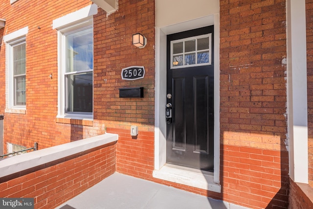 property entrance featuring brick siding