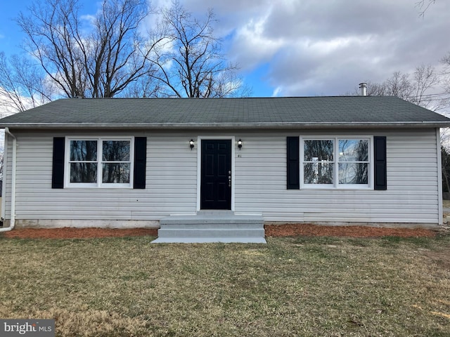 ranch-style home with a front lawn and roof with shingles