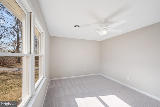 spare room with a ceiling fan, carpet, visible vents, and baseboards