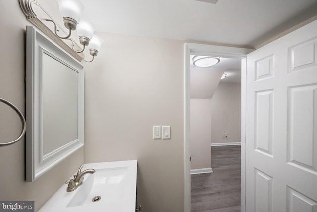 bathroom with wood finished floors, vanity, and baseboards