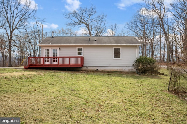 rear view of house featuring a lawn and a wooden deck