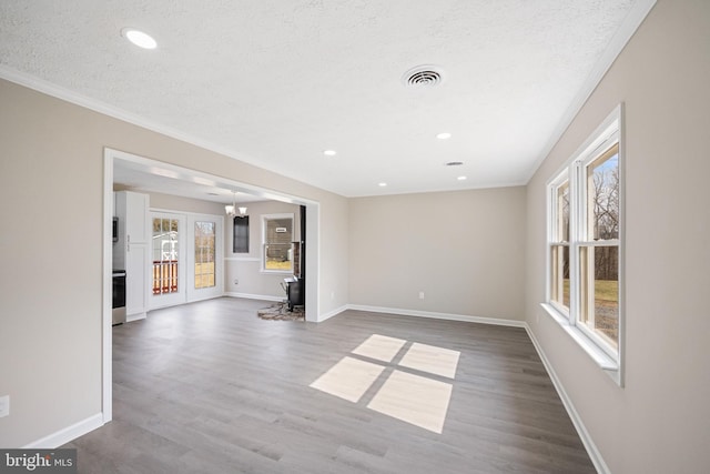 empty room with baseboards, visible vents, and wood finished floors