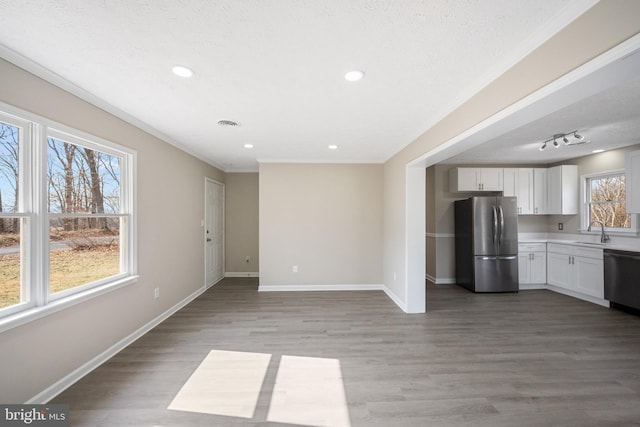 kitchen with stainless steel appliances, a sink, baseboards, white cabinets, and light wood-type flooring