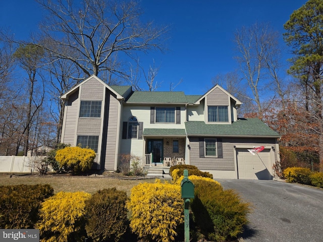 view of front of house with fence, driveway, and an attached garage