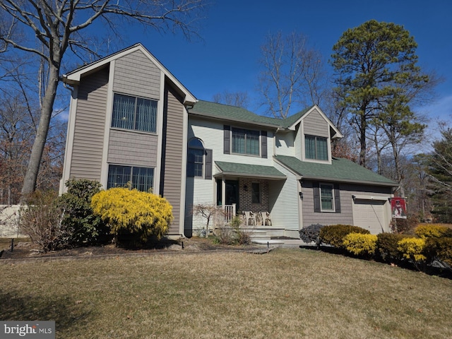 traditional-style house featuring a garage, covered porch, and a front lawn