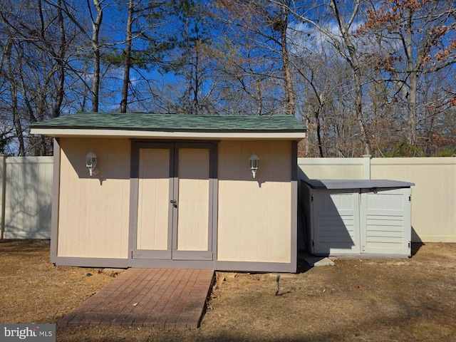 view of shed featuring fence