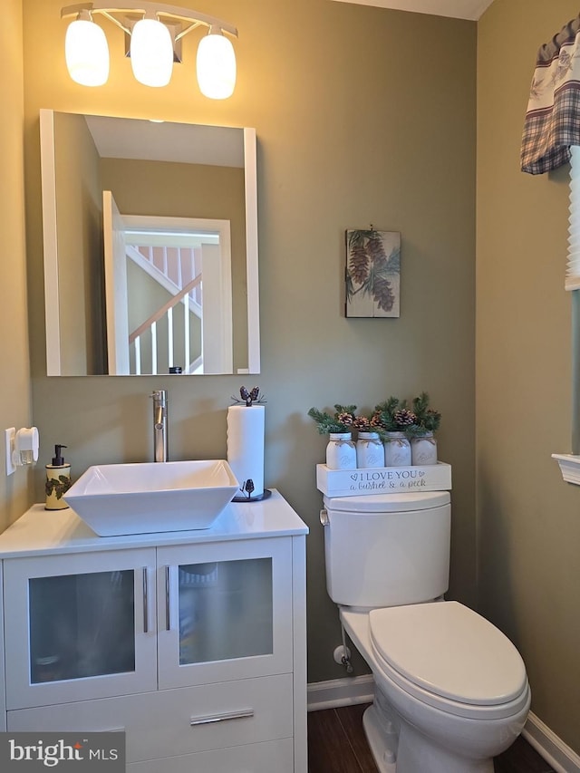 bathroom with vanity, toilet, and baseboards