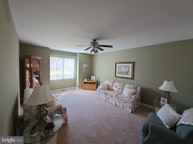 carpeted living room featuring ceiling fan and baseboards