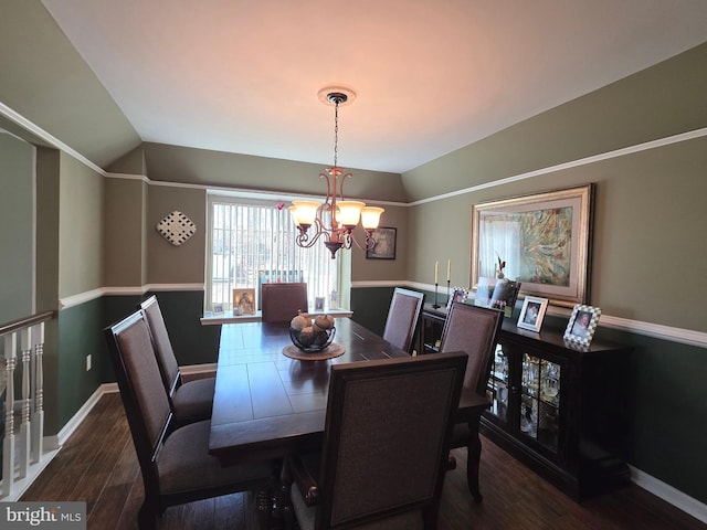 dining room featuring lofted ceiling, dark wood finished floors, a notable chandelier, and baseboards