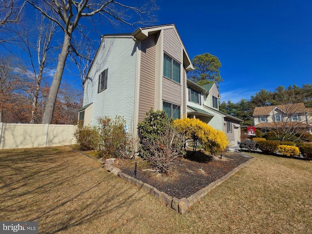 view of property exterior featuring a yard and fence