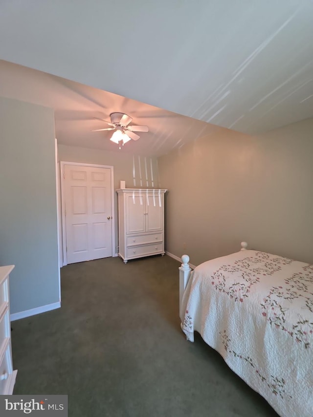 unfurnished bedroom featuring ceiling fan, dark colored carpet, and baseboards