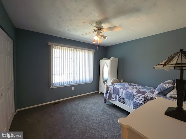 bedroom featuring visible vents, dark carpet, baseboards, and ceiling fan