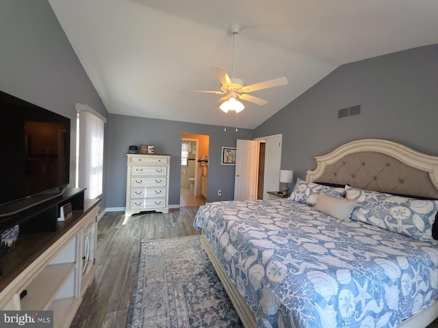 bedroom with visible vents, vaulted ceiling, ensuite bath, wood finished floors, and baseboards