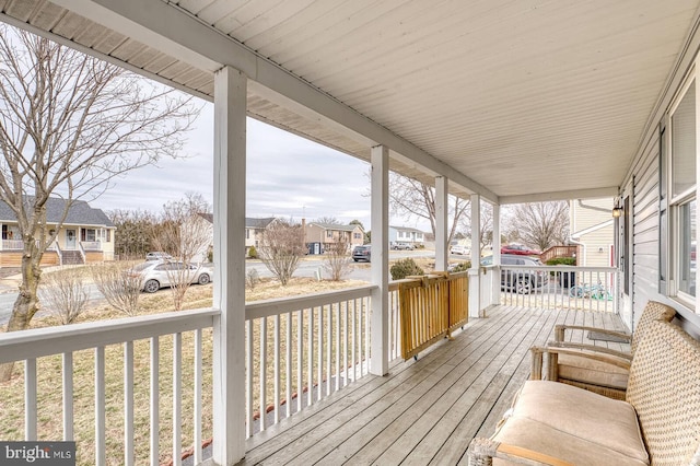 wooden terrace featuring covered porch and a residential view