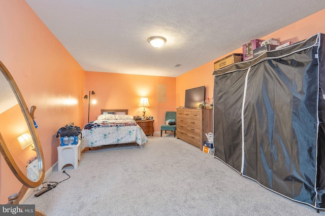 carpeted bedroom with a textured ceiling and baseboards