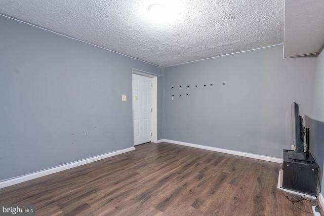 interior space featuring a textured ceiling, baseboards, and wood finished floors