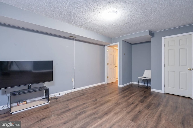 living room featuring visible vents, a textured ceiling, baseboards, and wood finished floors