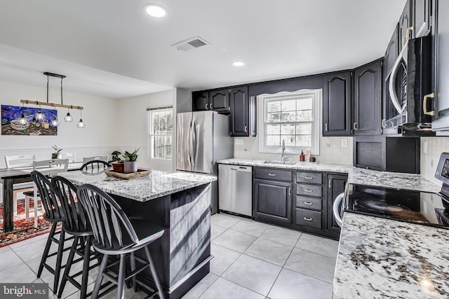 kitchen featuring appliances with stainless steel finishes, visible vents, a sink, and light tile patterned flooring