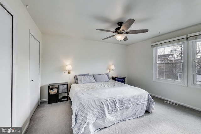 bedroom featuring carpet floors, visible vents, baseboards, and a ceiling fan