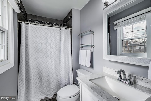 bathroom with toilet, curtained shower, and vanity