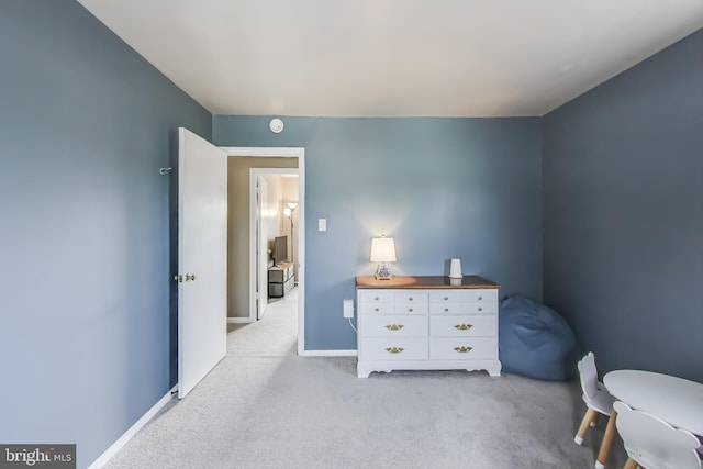 bedroom featuring baseboards and light colored carpet