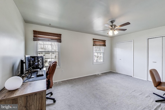 office area featuring carpet floors, a healthy amount of sunlight, visible vents, and a ceiling fan