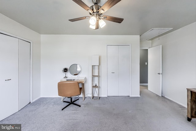 interior space featuring attic access, a ceiling fan, and carpet flooring