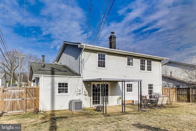 rear view of house with central AC unit, a chimney, a gate, fence, and a patio area