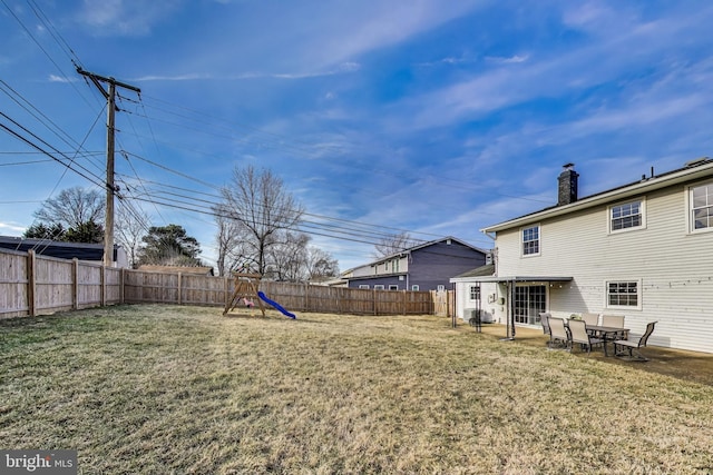 view of yard featuring a fenced backyard, a playground, and a patio