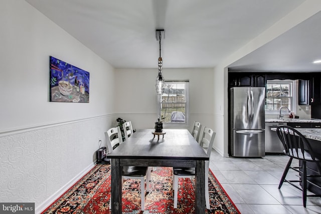 dining space with baseboards, a wealth of natural light, and light tile patterned flooring