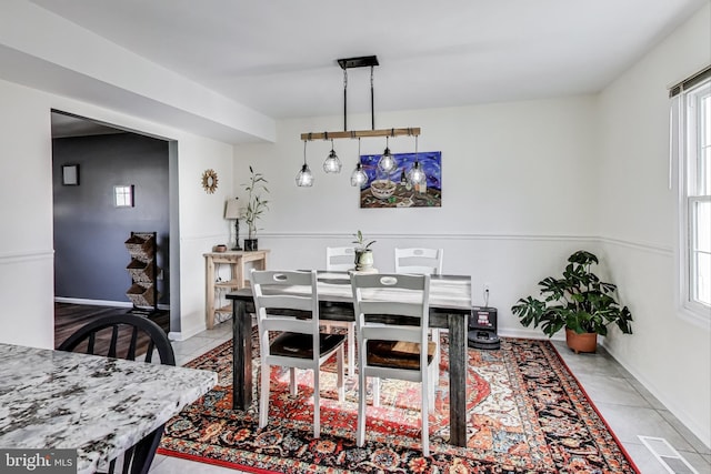 dining room with light tile patterned floors, visible vents, and baseboards