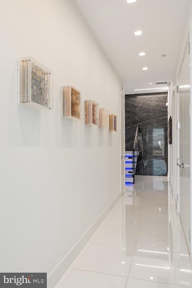 hallway featuring baseboards and tile patterned floors