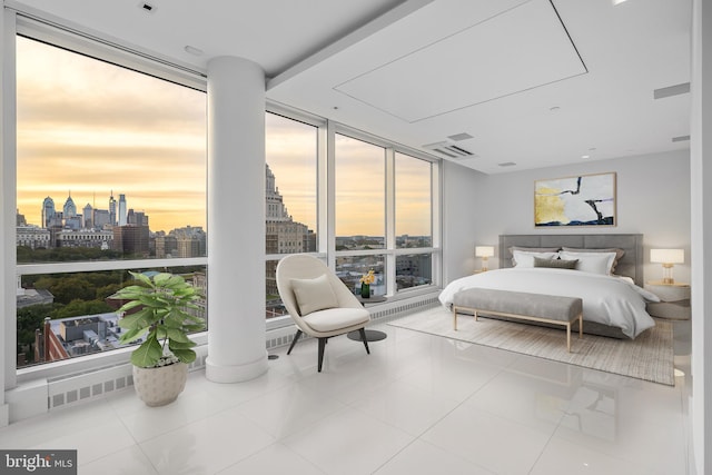 tiled bedroom with a view of city, a wall of windows, and visible vents