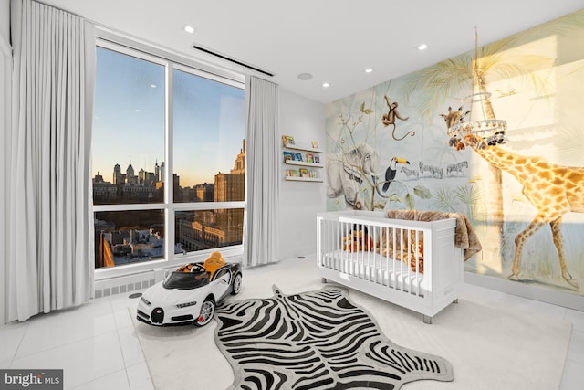 bedroom featuring tile patterned flooring, an accent wall, a city view, and recessed lighting