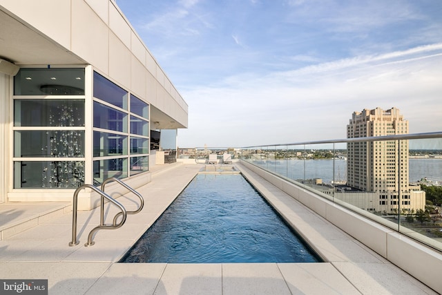 view of swimming pool with a water view and a view of city