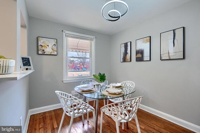 dining space featuring baseboards and wood finished floors