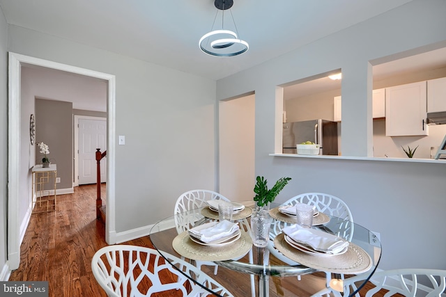 dining room with baseboards and dark wood-style flooring