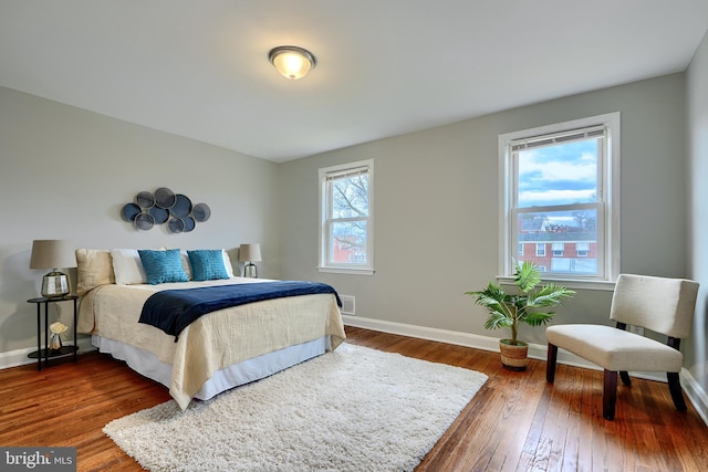 bedroom featuring dark wood-style floors, visible vents, and baseboards