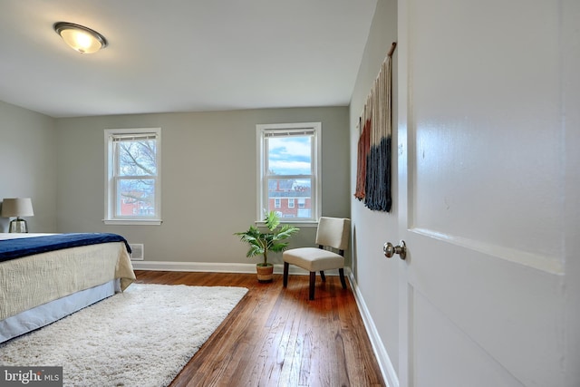 bedroom with hardwood / wood-style floors, multiple windows, and baseboards