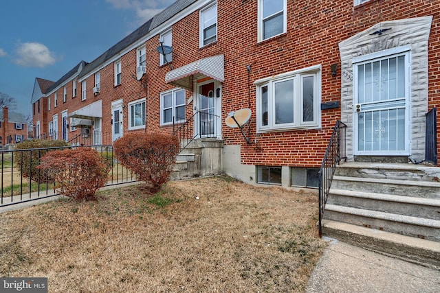 exterior space with brick siding, fence, and a residential view