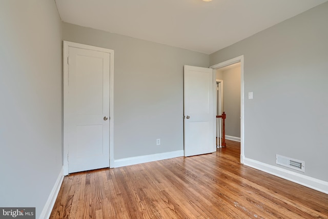 unfurnished bedroom featuring light wood-style flooring, visible vents, and baseboards