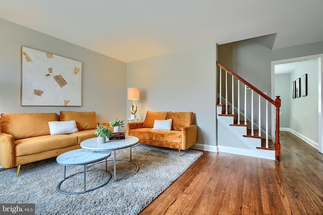 living area featuring stairs, wood finished floors, and baseboards